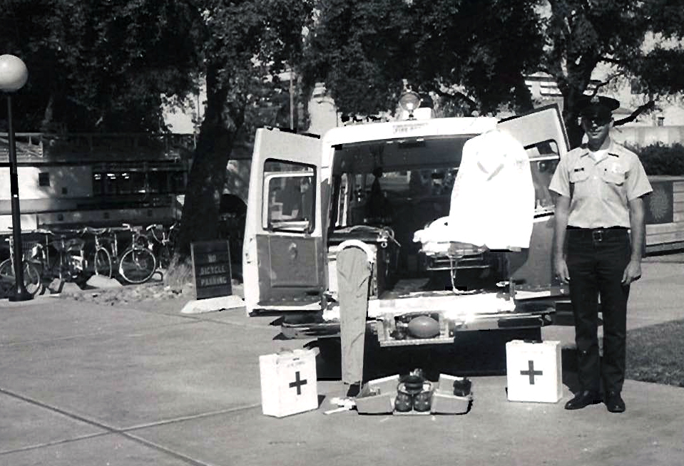 UC Davis Firefighter Stands next to a UC Davis ambulance.