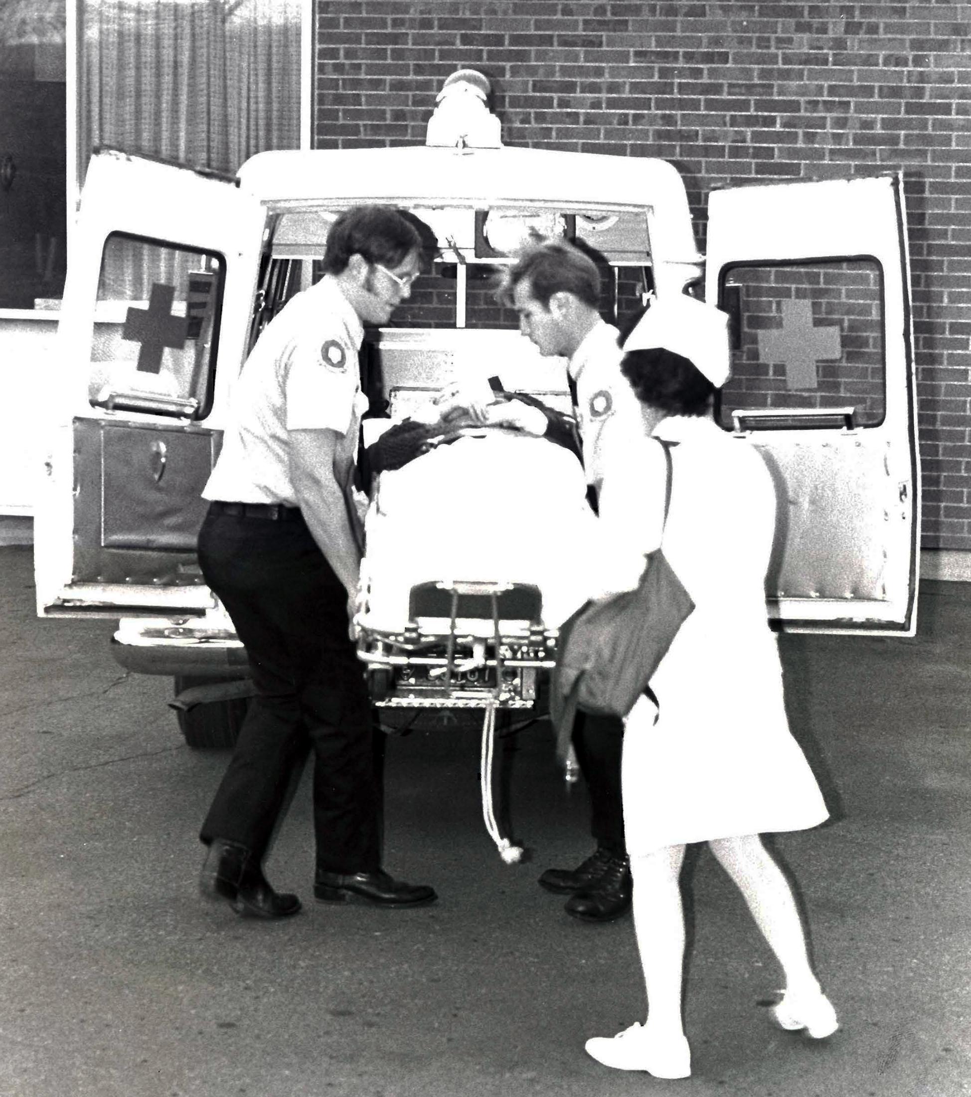 UC Davis Firefighters and Student Health Nurse load a patient into the back fo a waiting UC Davis ambulance.