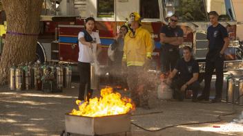 Firefighter extinguishing controlled fire in a demonstration