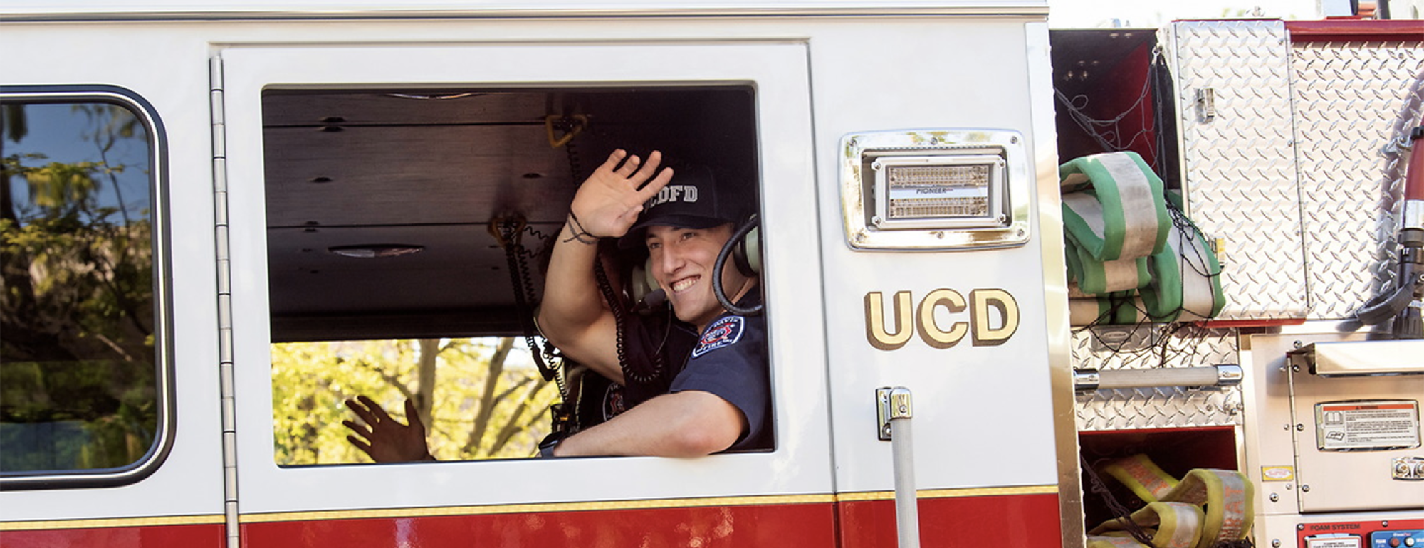 Student Firefighter waving from fire truck.