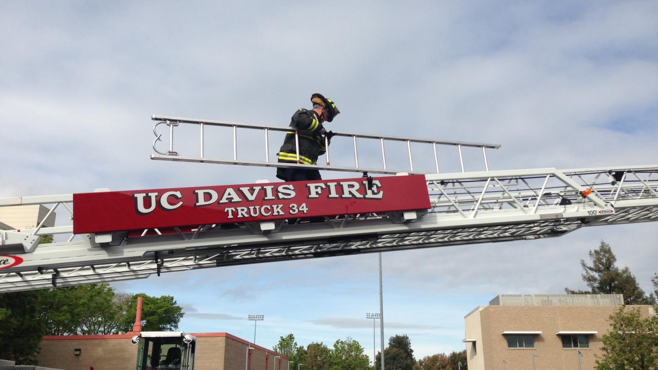 UC Davis Firefighter climbing aerial ladder