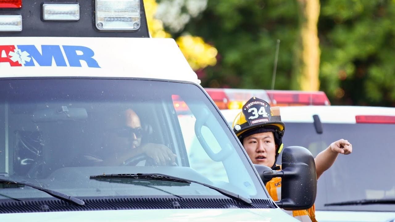 I firefighter provides direction to an ambulance at an emergency scene.