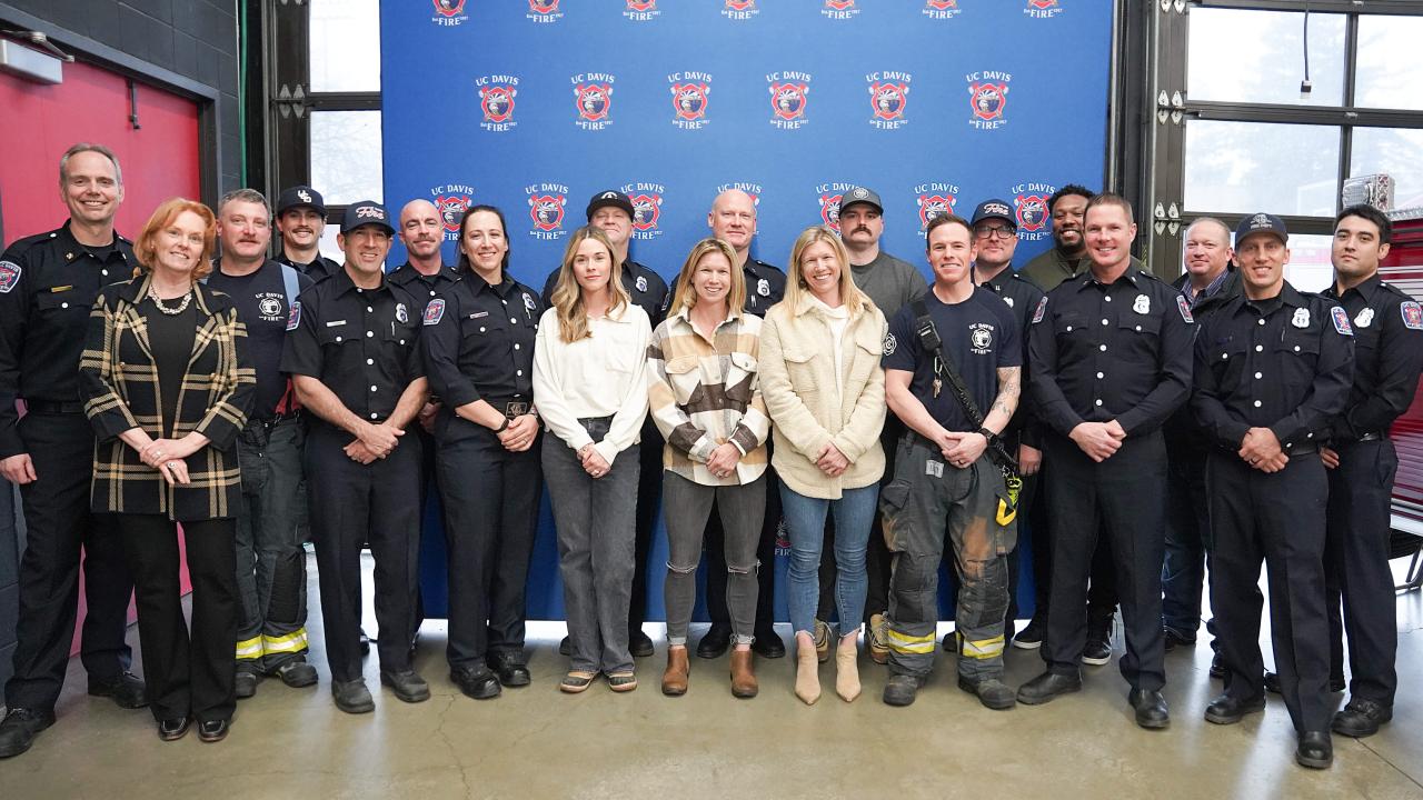 Fire Chief Nate Hartinger (first from left) and FOA Vice Chanellor Clare Shinnerl (second from left) stand and smile with the univerisity's firefighters