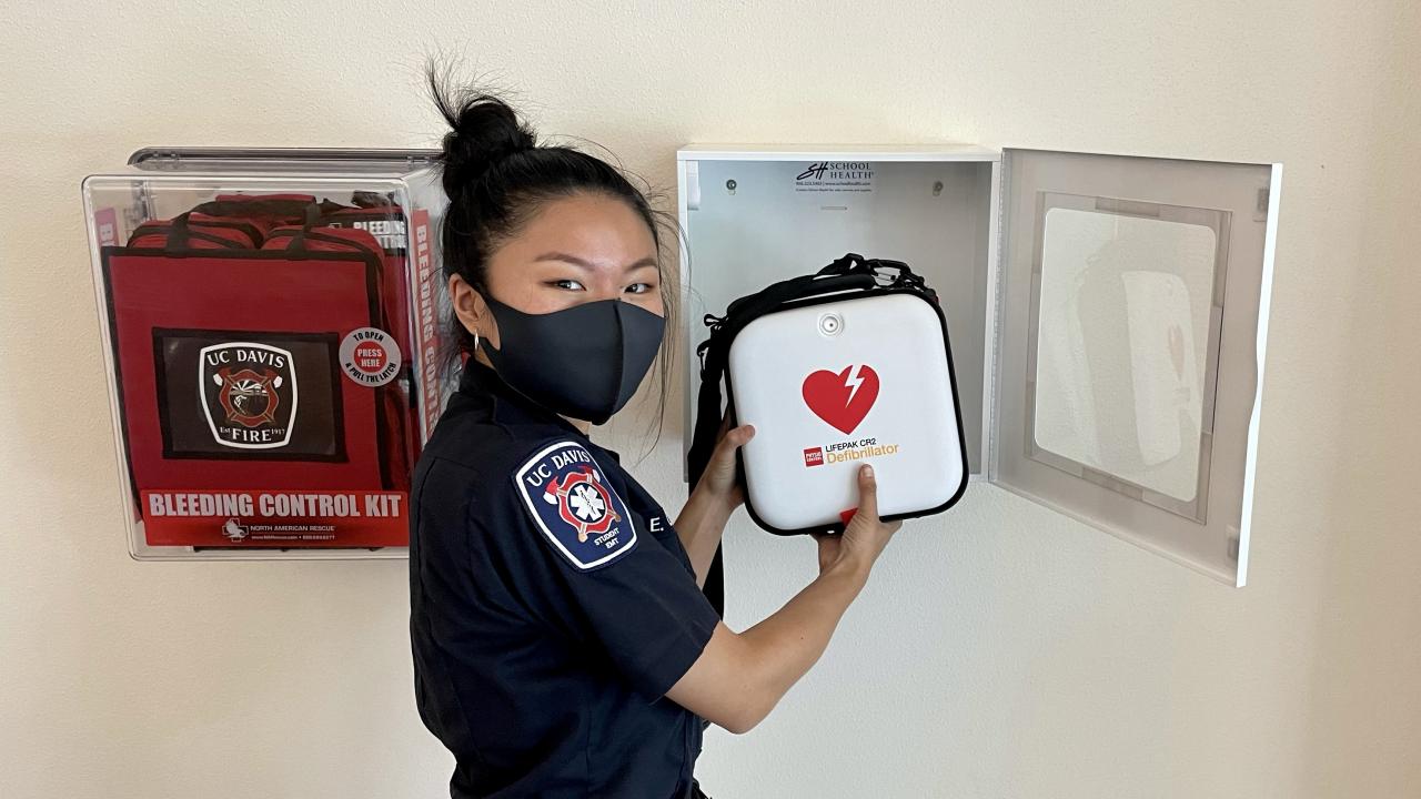 UC Davis Fire Student EMT checks campus AED cabinet