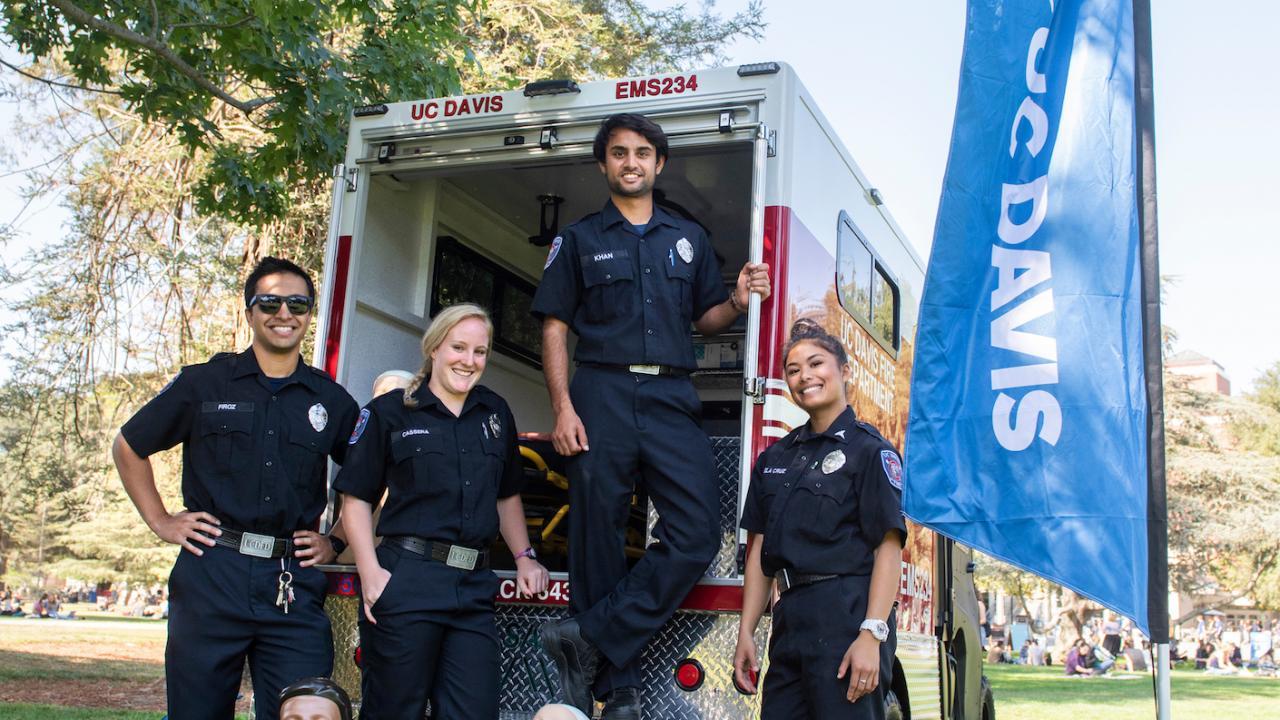 EMTs standing in front of the back of their firetuck.