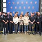 Fire Chief Nate Hartinger (first from left) and FOA Vice Chanellor Clare Shinnerl (second from left) stand and smile with the univerisity's firefighters