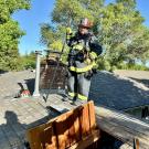 Steve Dunn, in his firefighting gear, stands on top of a roof.