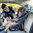 Ben Rizzo performing carseat inspection and ensuring child is safely place in car seat that is secured properly in the car.
