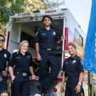 EMTs standing in front of the back of their firetuck.